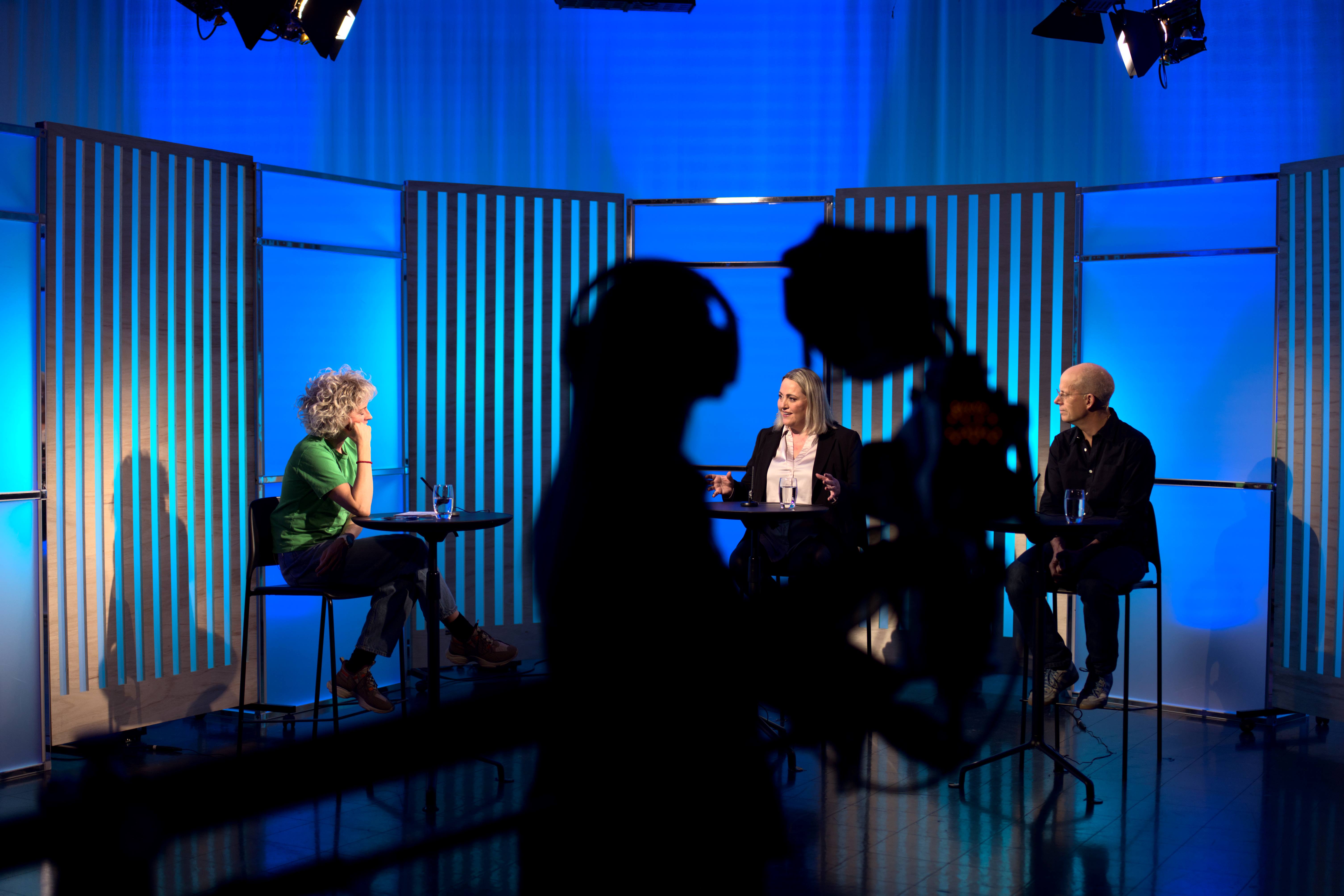 tv studio med gjester og kameraperson i silhuett