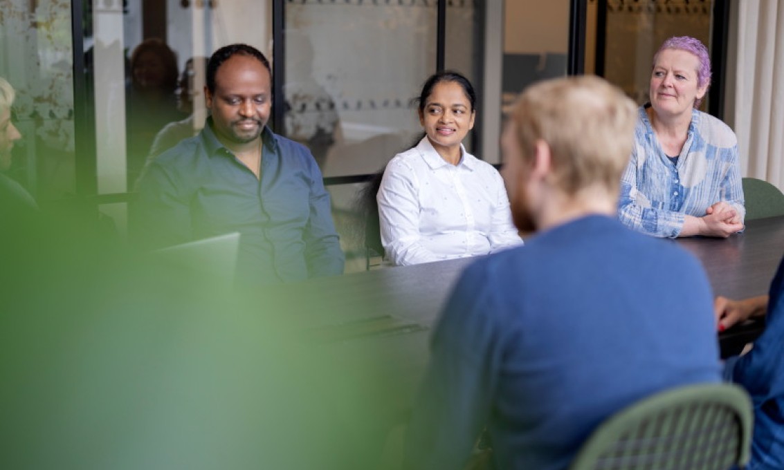 Fire personer sitter rundt et bord.