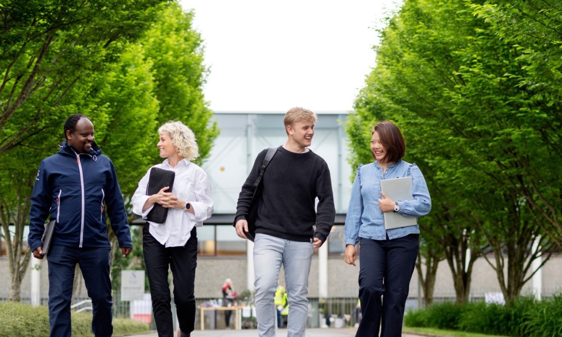 Fire personer går på en gangsti