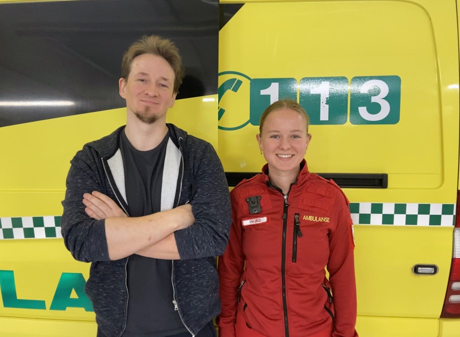 Nurse (without uniform) and paramedic in front of an ambulance.