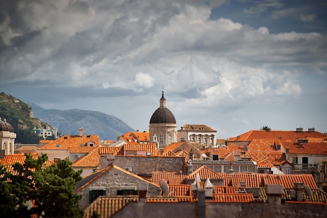 Utsikt over oransje hustak og fjell i bakgrunnen. Dubrovnik, Kroatia 